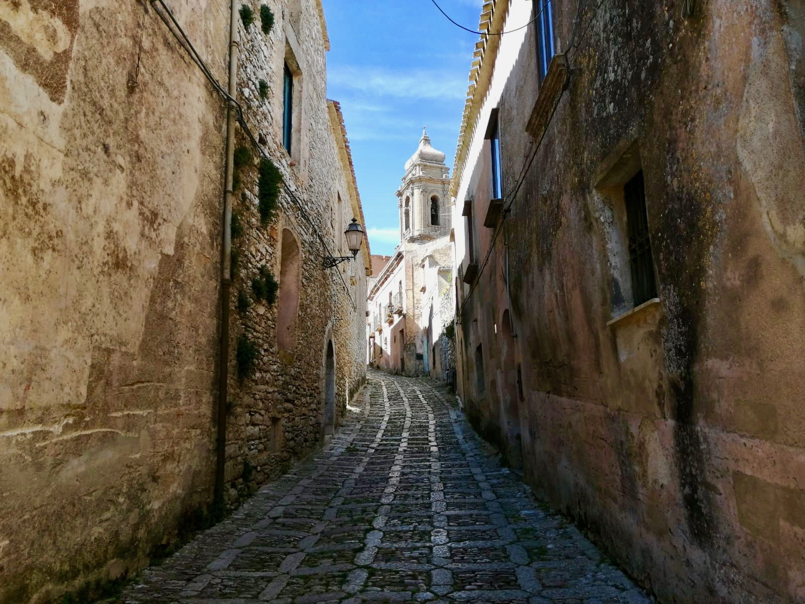 Narrow stone-paved medieval lane climbing through Erice